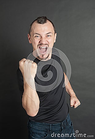 Young handsome man screaming with fist up protest gesture Stock Photo