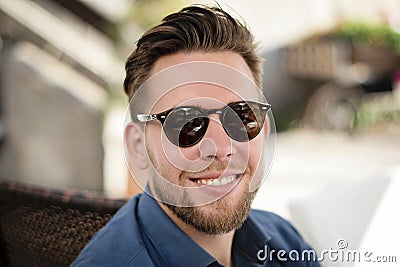 Young handsome man with sunglasses smiling outdoors Stock Photo