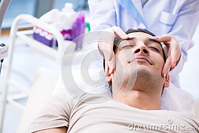 The young handsome man visiting female doctor cosmetologist Stock Photo