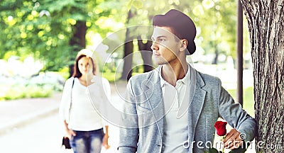 Young handsome man waiting for his girlfriend in the park. Stock Photo