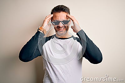 Young handsome man wearing funny thug life sunglasses meme over white background suffering from headache desperate and stressed Stock Photo