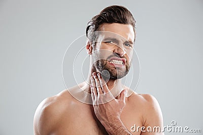 Young handsome naked man expertising his fce before shaving Stock Photo