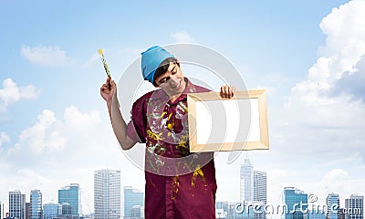 Young handsome painter artist holding paintbrush Stock Photo