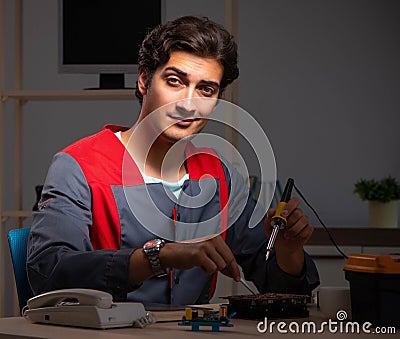 Young handsome repairman repairing computer Stock Photo