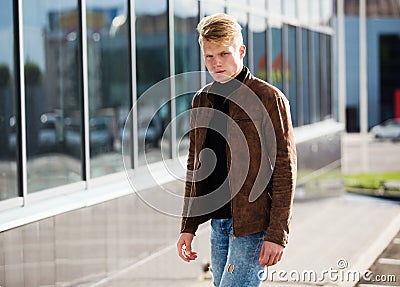 Young handsome stylish man in brown jacket in autumn time outdoor in casual style Stock Photo