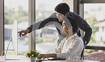 Young handsome teen older brother from lovely Asian family stand pointing computer monitor explaining when help teaching younger Stock Photo