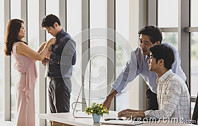 Young handsome teen sons from lovely Asian family pointing computer screen explaining when help teaching middle aged parent mother Stock Photo