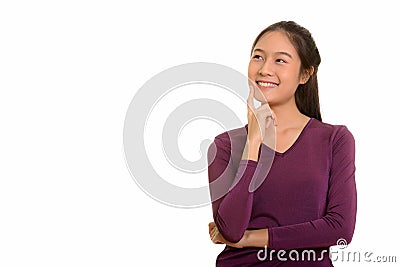 Young happy Asian teenage girl smiling and thinking Stock Photo