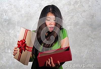 Young happy and beautiful Asian Chinese woman holding gift box receiving birthday or Christmas present opening the parcel excited Stock Photo