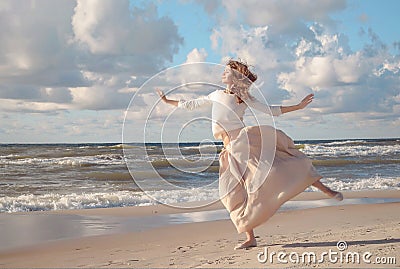 Young happy beautiful woman jumping on a beach in summer. Image of a woman jumping above the ocean at sunset, silhouette Stock Photo