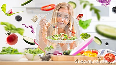 Young happy blonde girl eating healthy salad from arugula spinach tomatoes olives onion and olive oil Healthy vegetable concept Stock Photo