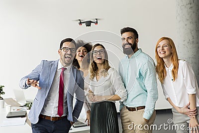 Young happy business people letting the drone camera to fly over the office and having fun Stock Photo