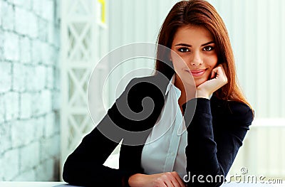 Young happy businesswoman sitting at the table on her workplace Stock Photo