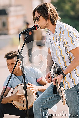 Young happy buskers drummer and guitarist playing music Stock Photo