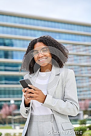 Young happy busy African American business woman using phone in city. Stock Photo