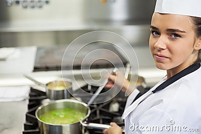 Young happy chef stirring sauce Stock Photo