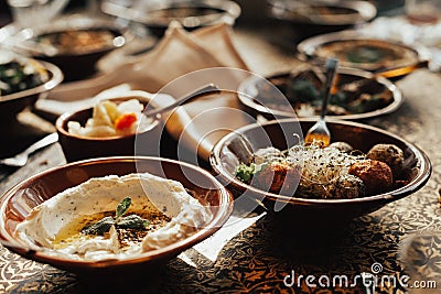 Young happy company of people is eating lebanon food and smokinh shisha. Lebanon cuisine. Stock Photo