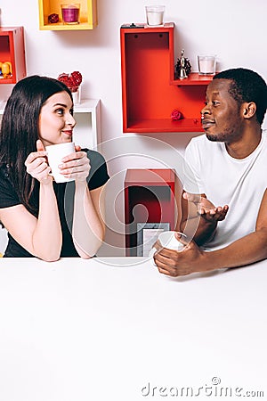 Young happy couple drink tea on kitchen, leisure Stock Photo