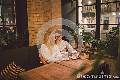 Young happy couple in love in cafe, man and woman together smile hugging, drinking coffee. Couple Talking In Cafe In Stock Photo