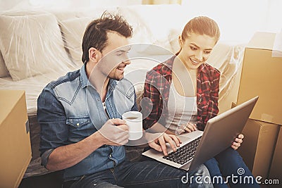 The young happy couple searching for apartments with laptop. Moving, purchase of new habitation Stock Photo
