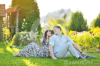 Young happy couple sitting back to back Stock Photo