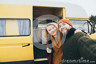 Young happy couple taking selfie in front of their camper van Stock Photo