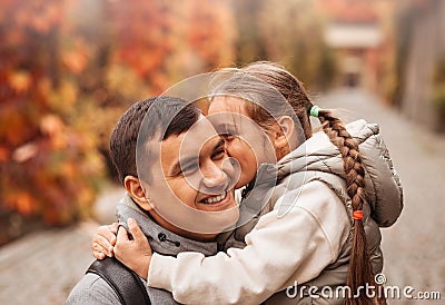 Young happy dad and little daughter hugging in autumn park. Family time, togehterness, parenting and happy childhood concept. Stock Photo