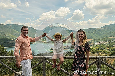 Young happy family on a background of a mountain lake Lago del Turano Stock Photo