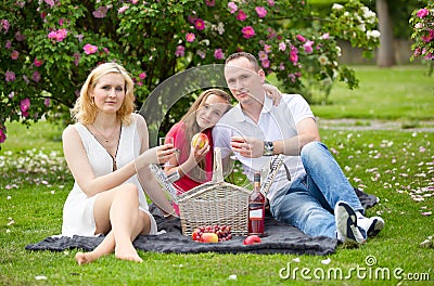 Young happy family having picnic outdoors Stock Photo