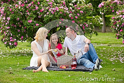 Young happy family having picnic outdoors Stock Photo