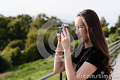 Young happy female photographer walks in the Park with retro camera Stock Photo