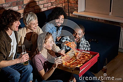 young happy friends eating pizza and watching movie or tv series at home Stock Photo