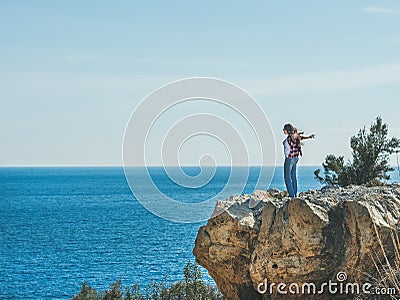 Young happy girl traveler standing on rock over sea, Turkey Stock Photo