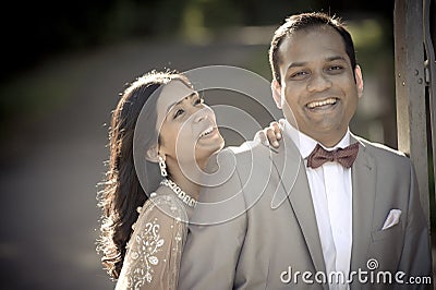 Young happy Indian couple laughing outdoors in sunshine Stock Photo