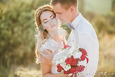 Young happy just married couple posing on the top of the mountain Stock Photo