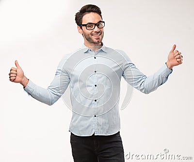 Young happy man showing presentation, pointing on placard over gray background Stock Photo