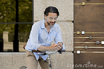 Young happy man smiling using mobile phone on vintage cool retro bike Stock Photo