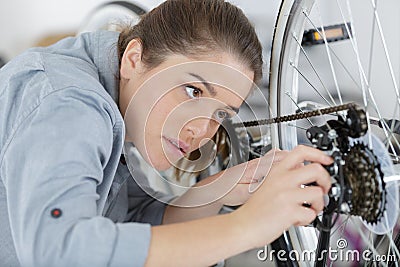 young happy positive woman master repairing bicycle in workshop Stock Photo