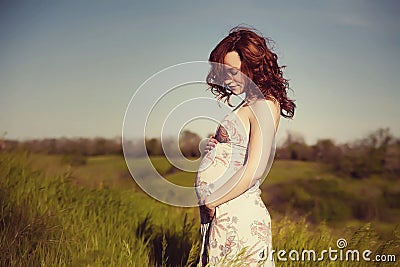 Young happy pregnant woman relaxing and enjoying life in nature. Stock Photo