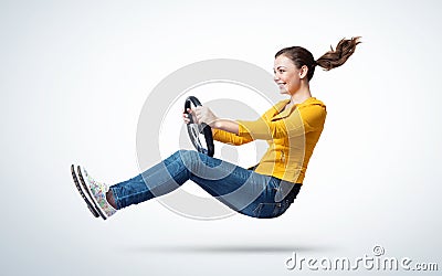 Young happy smiling girl drives a car with steering wheel in hands, auto concept Stock Photo