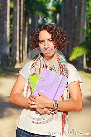 Young happy smiling woman (student, teacher) holding books and n Stock Photo