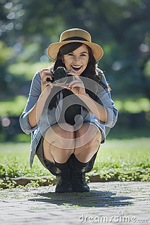 Young happy traveler exploring surrounds with film camera Stock Photo