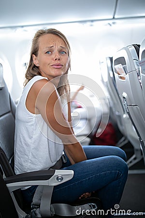 Young happy woman aboard an airplane during flight Stock Photo