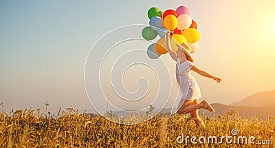 Happy woman with balloons at sunset in summer Stock Photo