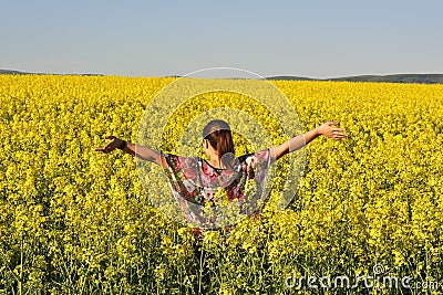 The Young happy woman on blooming rapeseed field in spring Stock Photo