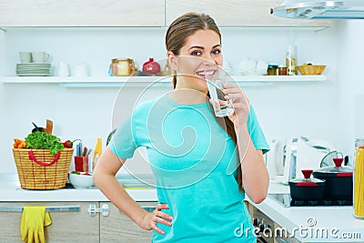 Young happy woman drink water standing in kitchen Stock Photo