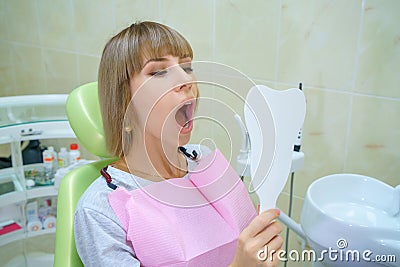 Young happy woman sitting in the dentist`s office, healthy teeth Stock Photo