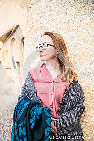 Young happy woman traveler enjoying a vacation in desert Cappadocia Turkey. Tourist blonde girl in glasses and pink shirt outdoor Stock Photo