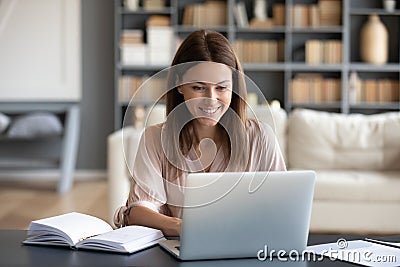 Young happy woman working on computer at home. Stock Photo