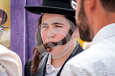 A young Hasid in a traditional Jewish hat and with long payos. Rosh Hashanah, Jewish New Year. Editorial Stock Photo